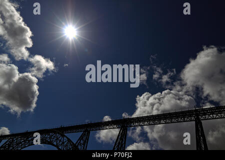 Backlit ferro vecchio ponte di Oporto con interessanti nuvole e cielo. Visualizzazione ampia. Foto Stock