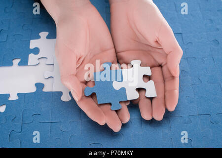 Immagine ritagliata di imprenditrice azienda assemblato bianco e blu puzzle, la concezione di business Foto Stock