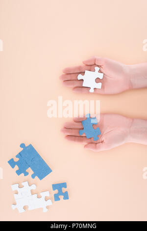 Immagine ritagliata di imprenditrice azienda blu e bianco puzzle in mani isolato sul beige, concetto di business Foto Stock