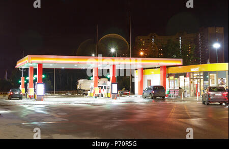 Stazione di gas durante la notte con le luci accese e mini-mart Foto Stock