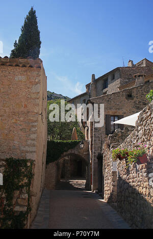 Un vicolo tranquillo (Rue de la Fontaine du quattro) nel borgo medievale di Saint-Guilhem-le-Désert; Hérault, Occitanie, Francia Foto Stock