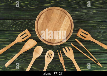 Vista superiore del round tagliere di legno e utensili da cucina sul tavolo Foto Stock