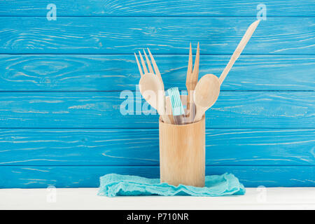 Vista ingrandita della RAG, pasticceria pennello e utensili da cucina di fronte blu parete in legno Foto Stock