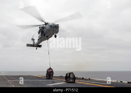 Oceano Pacifico (11 maggio 2017) un MH-60S Seahawk assegnato al "Jolly" di elicottero Attack Squadron 23 diminuisce il carico sul ponte di volo dell'assalto anfibio nave USS America (LHA 6) durante un rifornimento verticale. Più di 1.800 marinai e 2.600 marines assegnato all'America anfibio gruppo pronto (ARG) e il quindicesimo MEU stanno attualmente conducendo un composito unità di addestramento Esercizio (COMPTUEX) al largo della costa della California del Sud in preparazione per la ARG della distribuzione entro la fine di quest'anno. America ARG è costituito d'America, il dock anfibio sbarco nave USS Pearl Harbor (LSD 52), Foto Stock