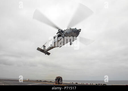 Oceano Pacifico (11 maggio 2017) un MH-60S Seahawk, assegnato al "Jolly" di elicottero Attack Squadron 23, decolla il ponte di volo dell'assalto anfibio nave USS America (LHA 6) dopo la caduta del carico durante un rifornimento verticale. Più di 1.800 marinai e 2.600 marines assegnato all'America anfibio gruppo pronto (ARG) e il quindicesimo MEU stanno attualmente conducendo un composito unità di addestramento Esercizio (COMPTUEX) al largo della costa della California del Sud in preparazione per la ARG della distribuzione entro la fine di quest'anno. America ARG è costituito d'America, il dock anfibio sbarco nave USS Pera Foto Stock