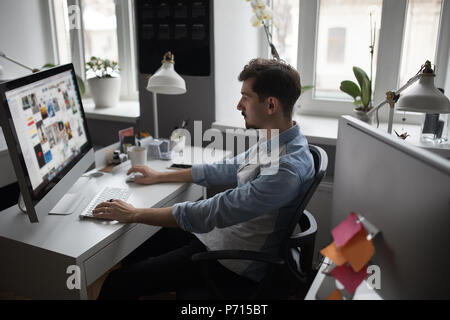 Giovani intelligenti barbuto uomo che lavora presso i moderni loft studio-offi Foto Stock