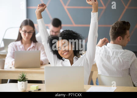 Felice dipendente nero lo stiramento in cattedra dopo il lavoro di finitura Foto Stock