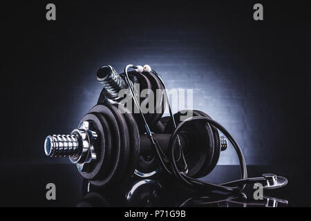 Vista ravvicinata di uno stetoscopio e manubri, uno stile di vita sano concetto Foto Stock