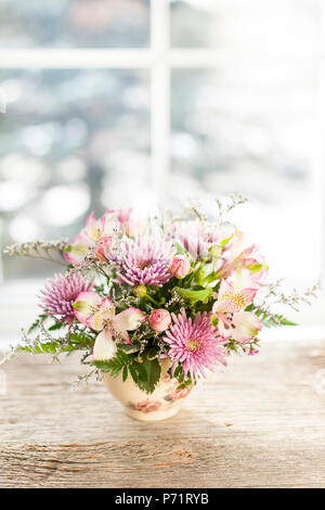 Bouquet di fiori colorati disposti in piccolo vaso Foto Stock