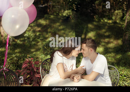 Matura in amore - inizio di una storia d'amore. Un uomo e una ragazza romantica data in un parco Foto Stock