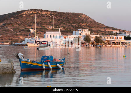 La pesca in barca in porto con la città dietro, Pollonia Milos, Cicladi, il Mare Egeo e le isole greche, Grecia, Europa Foto Stock