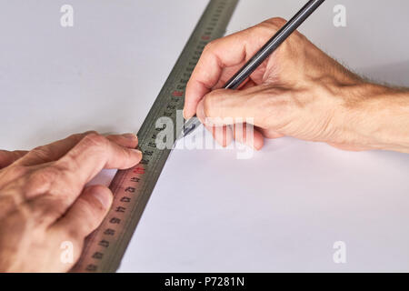 Marcatura le mani una lavagna, ruller e matita su un tappeto verde sullo sfondo Foto Stock