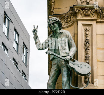 Statua di John Lennon tenendo la chitarra e dando V segno, dura giornata di notte Hotel, N John Street, Liverpool, England, Regno Unito Foto Stock