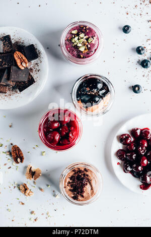 Vista superiore di vari dolci gustosi dessert in vasetti di vetro Foto Stock