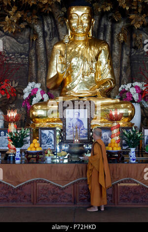 Golden Buddha con fiore di loto e monaco buddista, Minh Dang Quang tempio buddista, Ho Chi Minh City, Vietnam, Indocina, Asia sud-orientale, Asia Foto Stock