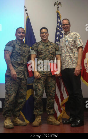 Sgt. Il Mag. Phillip Billiot, il sergente maggiore del quartier generale battaglione, Cpl. Paolo Franco, un rifleman con 3° Battaglione, 3° Reggimento Marine e Steve Auerbach, un solare pronto veterinari corso istruttore, posano per una foto durante la SRV cerimonia di laurea presso il teatro a bordo di Marine Corps base Hawaii il 11 maggio 2017. Il corso di sei settimane previsto i Marines con conoscenze di base dei sistemi fotovoltaici e li preparò per la North American Board of Certified praticanti di energia PV associa l'esame. Dopo il completamento dell'esame, i Marines saranno qualificati per energia solare professioni connesse. Foto Stock