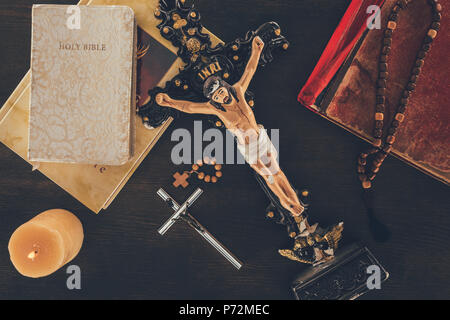 Vista dall'alto della croce con Gesù e bibbie sul tavolo di legno Foto Stock