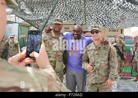 Paracadutisti dal 2 BCT, ottantaduesima Airborne Division, pongono con stand-up comico, Rawle Lewis, vicino Makhmour, Iraq, 11 maggio 2017. Lewis eseguito come parte della commedia compagni tour, sponsorizzato da forze armate di intrattenimento, il servizio ufficiale di agenzia della difesa di intrattenimento per distribuito il personale militare. I paracadutisti, distribuito come supporto delle Combined Joint Task Force-Operation inerenti risolvere, abilitare la loro sicurezza irachena vigore partner attraverso il consigliare e assistere la missione, contribuendo pianificazione, raccolta di intelligence e di analisi, forza di protezione, e gli incendi di precisione a achi Foto Stock