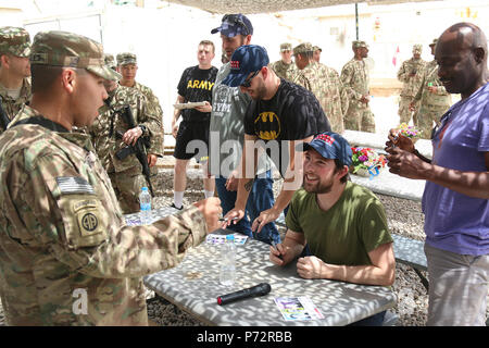 Stand-up comics, da destra, Rawle Lewis, Steven Briggs, Heath Harmison, e Sean Kent firmare autografi per i paracadutisti dal 2 BCT, ottantaduesima Airborne Division, vicino Makhmour, Iraq, 11 maggio 2017. La loro mostra, intitolata la commedia compagni Tour, è stato sponsorizzato da forze armate di intrattenimento, il servizio ufficiale di agenzia della difesa di intrattenimento per distribuito il personale militare. I paracadutisti, distribuito come supporto delle Combined Joint Task Force-Operation inerenti risolvere, abilitare la loro sicurezza irachena vigore partner attraverso il consigliare e assistere la missione, contribuendo pianificazione, intelligence riuniscono Foto Stock