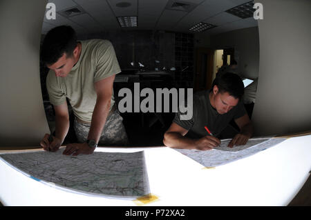 1Lt. Charles Fitzgerald (sinistra), da Birmingham, ala, e 2° Lt. Tyler Barnes di Hershey, Pa., costruire le mappe di cui avranno bisogno per navigare un OH-58 elicottero durante il basic warfighter competenze porzione di ad ala rotante addestramento di volo presso la Libreria tecnica sulla Fort Rucker, Ala. Giugno 6, 2013. Foto Stock