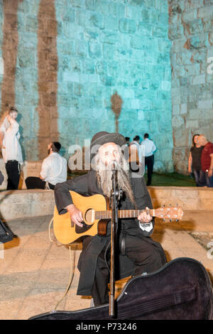 Gerusalemme, Israele. 3 lug 2018. Un ultra-ortodossi ("Haredi') uomo di suonare una chitarra vicino alle mura della città vecchia di Gerusalemme durante il 2018 Festa delle luci. Questo è il decimo anniversario del festival, festival, Israele, Gerusalemme, Gerusalemme. La Festa delle Luci nella Città Vecchia, ebraica, che attira centinaia di migliaia di visitatori della città vecchia di Gerusalemme, che è illuminato da molte sculture di luce e mostra Credito: Yagil Henkin/Alamy Live News Foto Stock