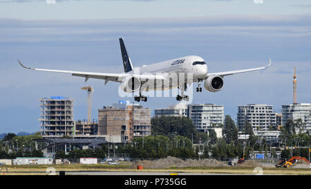 Richmond, British Columbia, Canada. 2 Luglio, 2018. Un Lufthansa Airbus A350-900 (D-AIXK) extra wide body aereo jet, dipinta in compagnia aerea è di nuovo look livrea, airborne sull approccio finale per l'atterraggio all'Aeroporto Internazionale di Vancouver, passa dal nuovo alto edificio in costruzione condominio a Richmond, British Columbia, Canada. Credito: Bayne Stanley/ZUMA filo/Alamy Live News Foto Stock