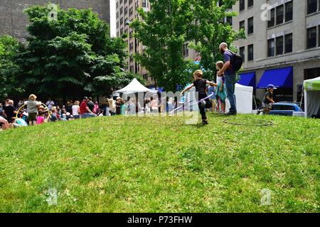 Chicago, Illinois, Stati Uniti d'America. I bambini giocano con rollbar di Hula come altri prendere in un concerto in un piccolo parco come parte delle stampanti annuale fila accesa Fest. Foto Stock