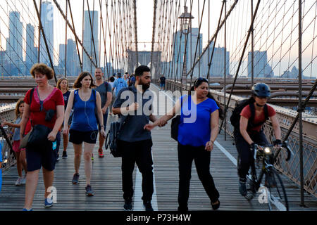 I pedoni e i ciclisti evitano il conflitto sul percorso pedonale del ponte di Brooklyn sul fiume East a New York, New York. Foto Stock
