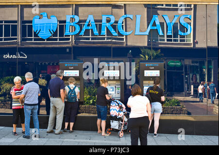 I clienti al di fuori della coda Barclays Bank sportelli bancomat in Plymouth Devon England Regno Unito Foto Stock