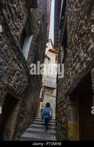 Donna salite le scale attraverso uno stretto vicolo Foto Stock