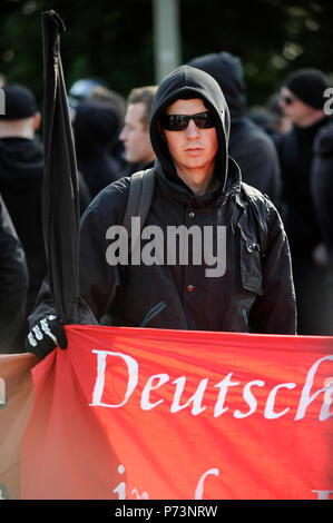 Germania, rally del nazismo e del diritto dei gruppi estremisti in amburgo, mummed protester con banner con la parola deutsch-tedesco Foto Stock