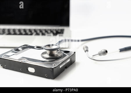 Lo stetoscopio e unità disco rigido su sfondo bianco. Hardware per computer diagnostica e riparare il concetto Foto Stock