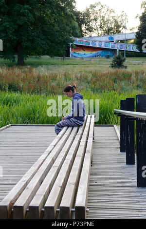 La donna si sedette sul banco in Hilbert & Grosvenor Park Foto Stock