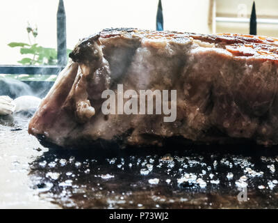 Un top bistecca di controfiletto arrostito alla fiamma su un barbecue, una profondità di campo ridotta. Foto Stock