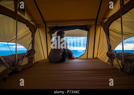 Lonely forte indipendente di mezza età sentimento donna la natura outdoor in una tenda del tetto sulla vettura. viaggi e lifestyle wanderlust concept per il bellissimo Foto Stock