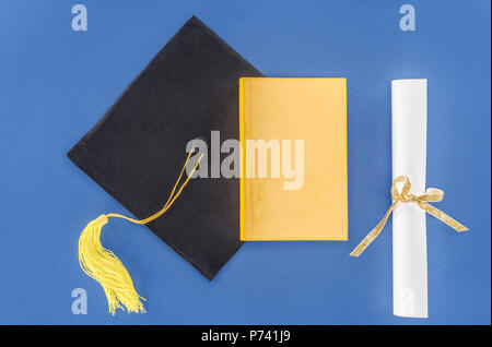 Graduazione hat con diploma e prenota isolato su blu Foto Stock
