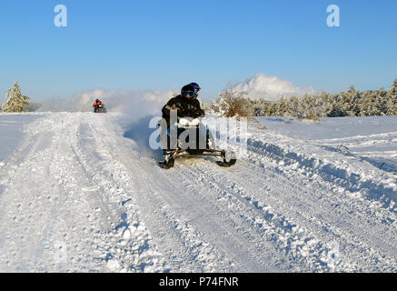 Le mans passa su una motoslitta sulla neve road Foto Stock