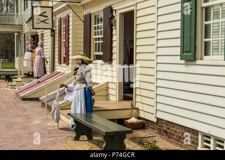 Williamsburg, Virginia, Stati Uniti d'America - 1 Aprile 2018 : donna vestito in abiti storici in piedi di fronte a una casa Foto Stock