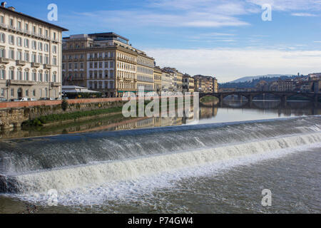 Firenze, Italia - 25 novembre 2015: fiume Arno a Firenze con una piccola cascata e ponte vecchio in background Foto Stock