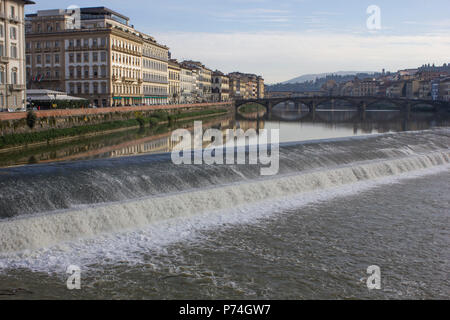 Firenze, Italia - 25 novembre 2015: fiume Arno a Firenze con una piccola cascata e ponte vecchio in background Foto Stock
