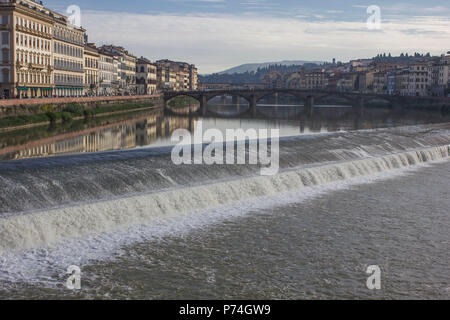 Firenze, Italia - 25 novembre 2015: fiume Arno a Firenze con una piccola cascata e ponte vecchio in background Foto Stock