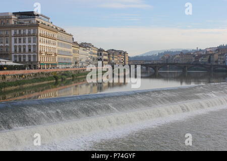 Firenze, Italia - 25 novembre 2015: fiume Arno a Firenze con una piccola cascata e ponte vecchio in background Foto Stock