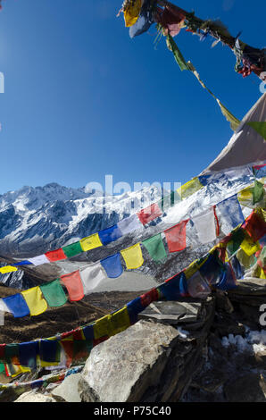 Bandiere di preghiera e montagne coperte di neve, vicino Kyanjin Gompa, Langtang Valley, Nepal Foto Stock