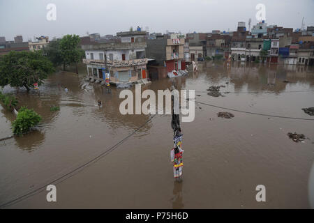 Pakistani residenti in Cina regime passando attraverso la strada allagata dopo le intense piogge monsoniche a Lahore. Il continuo pre-piogge monsoniche magia ha ancora una volta ha colpito la città. Almeno sei persone sono state uccise molti feriti in pioggia-incidenti correlati. Senza pietà come 238mm di pioggia ha continuato tre ore sommersi la maggior parte delle zone della città risultanti nella peggiore delle ipotesi gli inceppamenti di traffico nonché gravi disagi per i cittadini. Il Met Office ha detto che a causa di una pressione elevata correnti monsoniche penetrando nel paese, la capitale del Punjab, così come altre città, continuerà a ricevere acquazzone per i prossimi due d Foto Stock