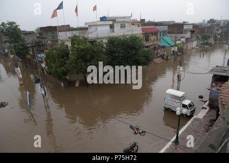 Pakistani residenti in Cina regime passando attraverso la strada allagata dopo le intense piogge monsoniche a Lahore. Il continuo pre-piogge monsoniche magia ha ancora una volta ha colpito la città. Almeno sei persone sono state uccise molti feriti in pioggia-incidenti correlati. Senza pietà come 238mm di pioggia ha continuato tre ore sommersi la maggior parte delle zone della città risultanti nella peggiore delle ipotesi gli inceppamenti di traffico nonché gravi disagi per i cittadini. Il Met Office ha detto che a causa di una pressione elevata correnti monsoniche penetrando nel paese, la capitale del Punjab, così come altre città, continuerà a ricevere acquazzone per i prossimi due d Foto Stock