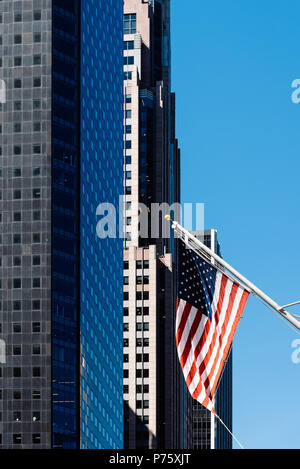 Bandiera americana agitando contro ufficio moderno edificio. Foto Stock