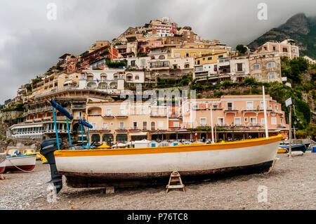 Barca a secco con il famoso villaggio di Positano in background, Costiera Amalfitana, Campania, Italia Foto Stock