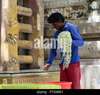 Bodhgaya,, India - Lug 9, 2015. Un uomo che prega al complesso del tempio di Mahabodhi. Il Mahabodhi Vihar è un sito Patrimonio Mondiale dell'UNESCO. Foto Stock