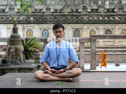 Bodhgaya,, India - Lug 9, 2015. Un uomo asiatico a praticare yoga meditazione al complesso del tempio di Mahabodhi a Bodhgaya,, India. Foto Stock