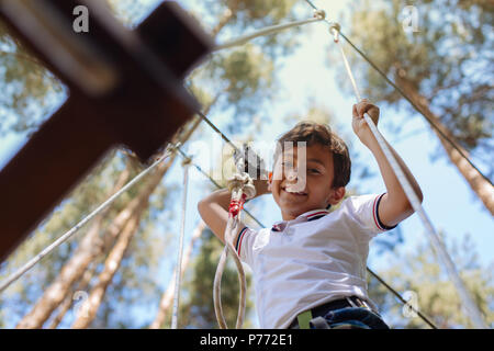 Upbeat preteen boy sorridente dal parco di corda trial Foto Stock